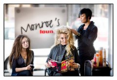 Bedrijfsfotografie voor redactionele doeleinde bij de kapper doet het haar van model een ander fotomodel kijkt mee gefotografeerd op locatie door fotograaf. www.marijnissenfotografie.nl