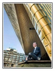 Fotograaf bedrijfsfotografie portret voor bedrijfswebsite van directeur zittend voor Rotterdam centraal gefotografeerd op locatie door fotograaf. www.marijnissenfotografie.nl