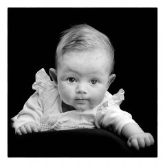 Babyfotografie newborn van baby die zich opgedrukt kijkend in de camera met een openblik in zwarte omgeving gefotografeerd door fotograaf in de fotostudio. www.marijnissenfotografie.nl