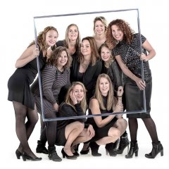 Vrijgezellen fotoshoot van 9 dames allemaal in het zwart die een lijst vasthouden waar ze zelf doorheen kijken wat nog al dringen is  gefotografeerd door fotograaf in de fotostudio Rotterdam  www.marijnissenfotografie.nl