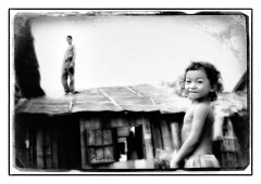 Vader_op_dak_en_kind_voor_huis_Cambodja.jpg