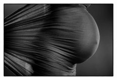 Zwangerschapsshoot van zwangerschapsbuik met donker doek close-up in donkere omgeving zwart-wit gefotografeerd in fotostudio Rotterdam. www.marijnissenfotografie.nl
